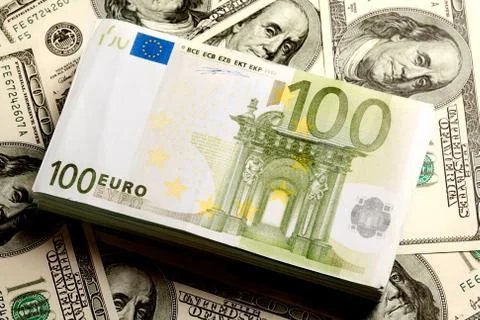 Close-up of heap of us dollars with a roll of euros on it Stock Photos