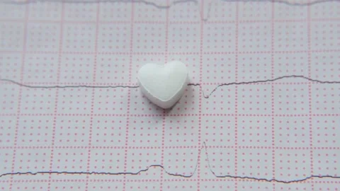 Close-up heart-shaped tablet on ECG background. Stock Footage 208002047