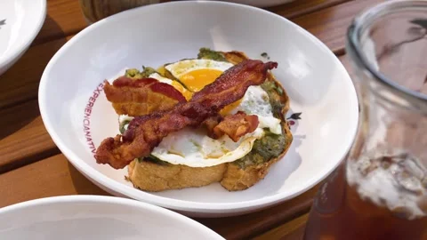 Close-Up of Hearty Breakfast Plate with Egg, Bacon and Avocado on Toasted Bread Stock Footage 336402589