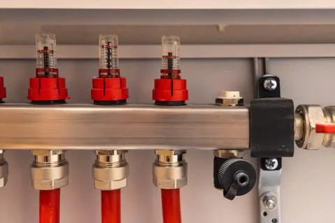 Close up of heating manifold flow control valves with connected pipes Stockfoto's