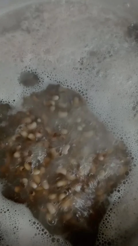 Close up of heavily boiling white beans in only water with foam. Stock Footage 311218986