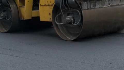 Close up of heavy road roller compacting fresh hot asphalt on new street Video stock 339802425