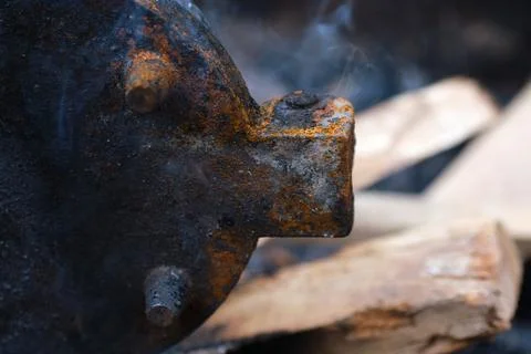 Close-up of a heavy rusty cast iron barbecue part heating over a wood fire Stock Photos
