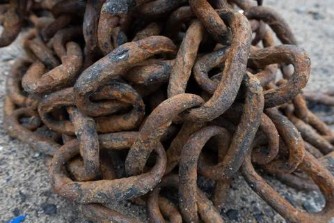 Close-up of a heavy rusty iron chain tangled in a pile on a ground Stock Photos