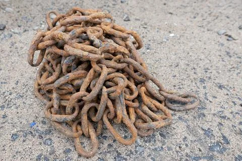 Close-up of a heavy rusty iron chain tangled in a pile on a ground Stock Photos