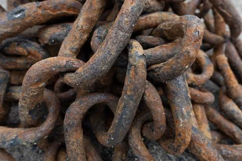 Close-up of a heavy rusty iron chain tangled in a pile on a ground Stock Photos