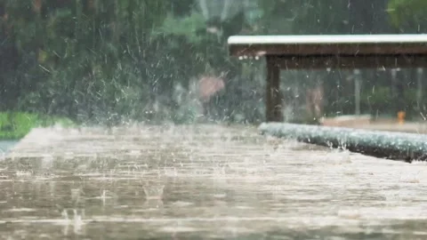Close up of Heavy Tropical Rain drops on tile pavement in city park Stock Footage 343907099