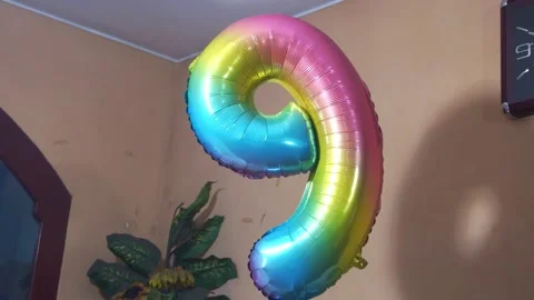 Close-up of a helium balloon in the shape of the number nine floating Video stock 155283024