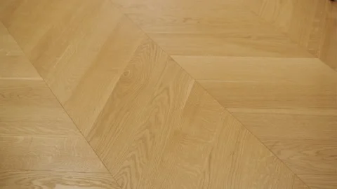 Close-up of a herringbone pattern wooden floor with a warm oak finish Stock Footage 270093674