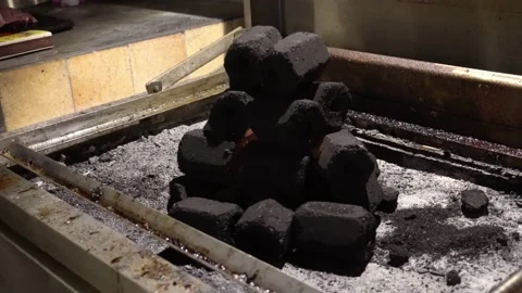 Close-up of a hexagon-shaped pile of coals on a grill with a fire flame inside 库存影片 186221222