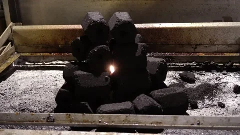 Close-up of a hexagon-shaped pile of coals on a grill with a fire flame inside Vidéo 186221692