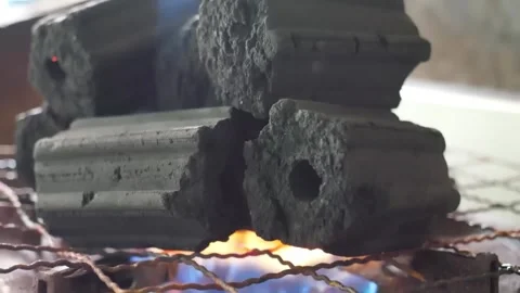 Close-up of Hexagonal Charcoal Briquettes Burning in Barbecue Grill with Blue Ga Video stock 338211131