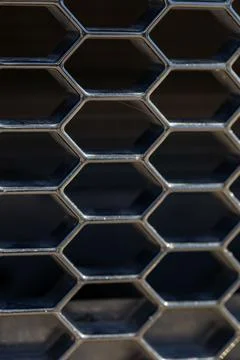 Close-up of a hexagonal metal grid pattern with a dark background. Fotos de archivo