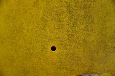 A close-up high-angle shot capturing a single small black circular hole Stock Photos