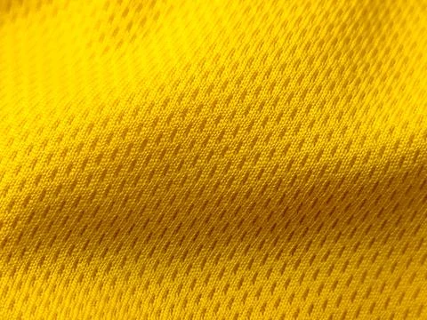 A close-up, high-angle shot featuring a bright yellow mesh fabric Stock Photos