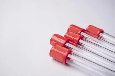 Close-up, high-angle shot of four empty medical blood collection tubes with.. Stock Photos