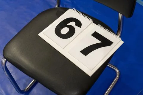 A close-up, high-angle shot of two white number signs, displaying the black.. Stock Photos