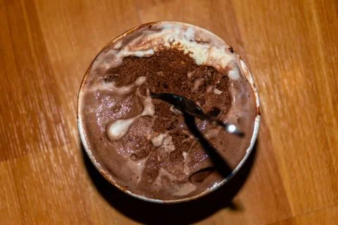 A close-up high angle view of a small bucket of melting chocolate ice cream w Stock Photos