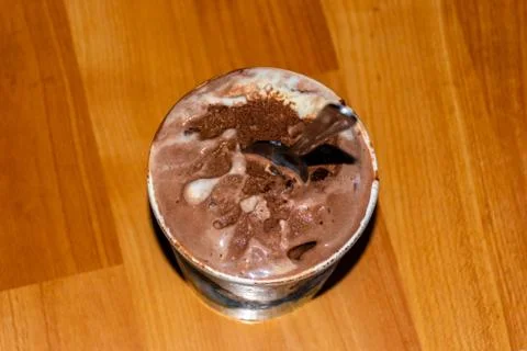 A close-up high angle view of a small bucket of melting chocolate ice cream w Stock Photos
