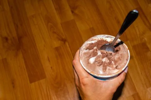 A close-up high angle view of a small bucket of melting chocolate ice cream w Stock Photos