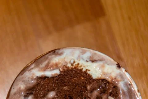 A close-up high angle view of a small bucket of melting chocolate ice cream w Stock Photos
