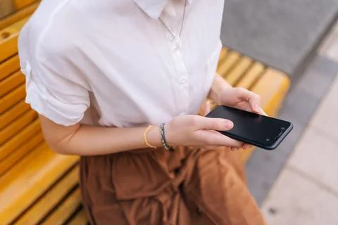 Close-up high-angle view of of unrecognizable young woman holding smartphone and Stock Photos