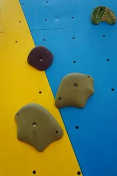 A close-up high-angle view of various textured plastic climbing holds mounted Stock-Fotos