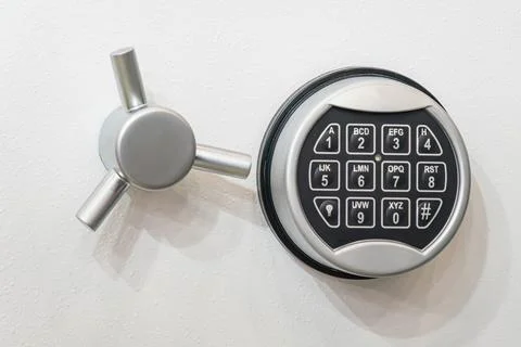 Close-up of a high-security electronic safe lock mechanism mounted on a white Stock Photos