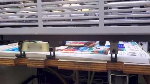 Close-up of high-speed industrial printing press feeding paper into mechanical Stock Footage 338027830