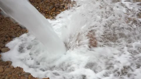 Close-Up of High-Velocity Water Stream Crashing into Rocky Dirt Basin Vídeos de archivo 334181635