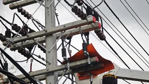Close up of high voltage utility riser pole with orange rubber insulating. Stock Photos