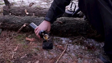 Close up of a hiker resting on a log and drinking tea from a thermos Stock Footage 211689833