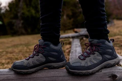 Close-Up of Hiking Boots Standing on Rustic Wooden Fence Stock-Fotos