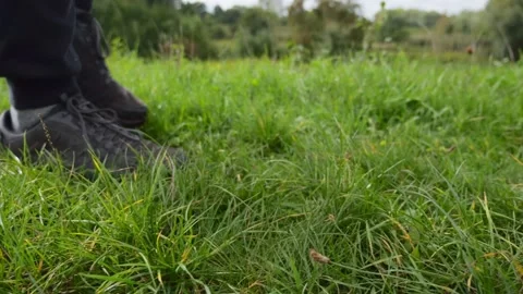 Close up of hiking boots walking in the grass, slow motion. Video stock 220215748