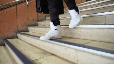 Close up of Hip Sneakers Walking Down Stairs - Gimbal Follow Shot Stock Footage 104482801
