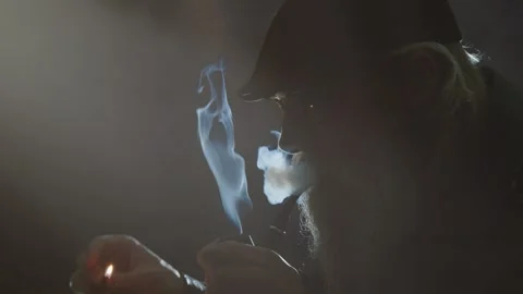 Close up hipster man lights pipe in darkness, creative stage lighting Video stock 310215858