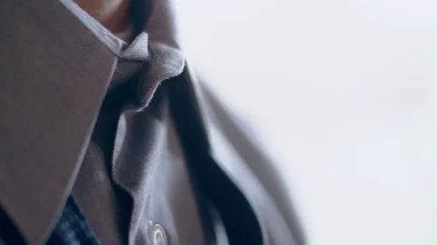 Close-up of hispanic man getting ready tying a necktie in the morning Stock Footage 84482946