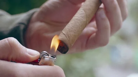 Close-up of hispanic man lighting end of fine cigar Stock Footage 84490186