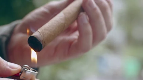Close-up of hispanic man lighting end of fine cigar Stock Footage 84490334