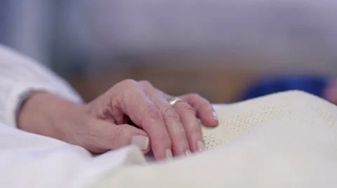 Close up holding the hand of an elderly patient in hospital bed. No faces can be Stock Footage