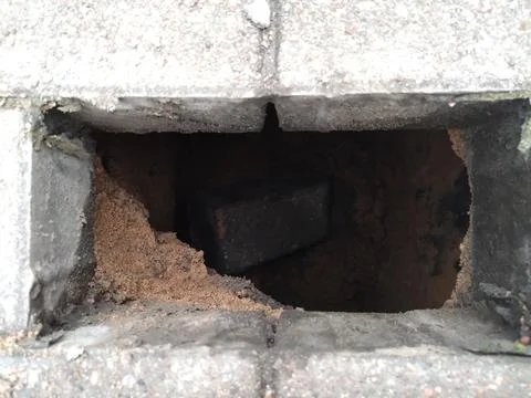 Close-Up of a Hole in a Paved Surface with Sand Inside Stock Photos