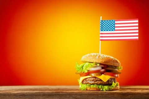 Close-up home made beef burger with american flag on the top on wooden table  Stock Illustration