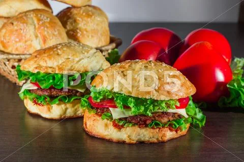 Close-up of home made tasty burgers on wooden table Stock Photos
