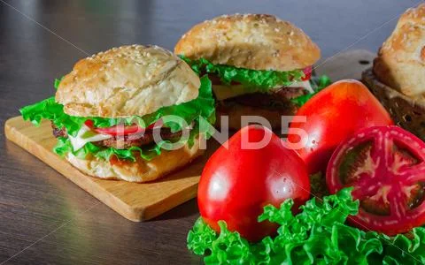 Close-up of home made tasty burgers on wooden table Stock Photos