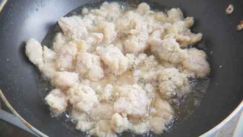 Close up of homemade Chicken pops being fries in a small pan on a stove - 1 Vidéo 100618136