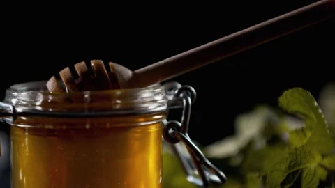 Close up of a honey jar, using honey dipper to scoop it, 4k Stock Footage 141570552