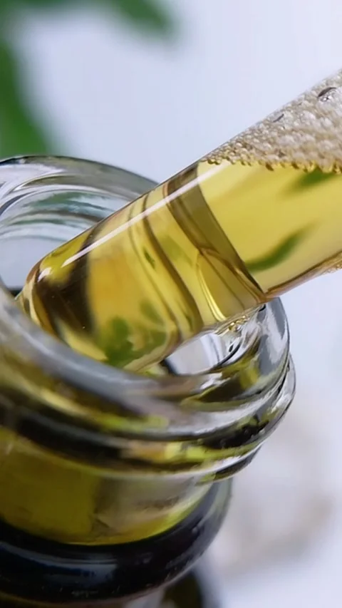 Close up of honey tea liquid bubbling inside pipet above bottle. Natural sk.. Stock Footage 340562615