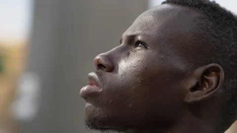 Close up on hope, optimism for the future.Young black man looking up Stock Footage 92390135