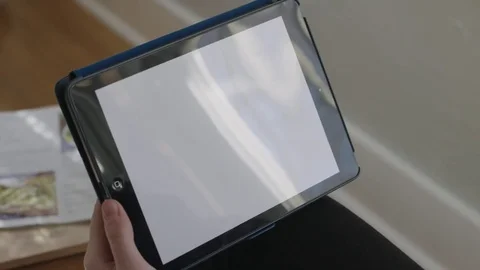 Close up of horizontal tablet as a young lady's hand swipes and holds Stock Footage 70809392