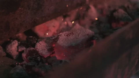 Close-up of hot coals in the grill are smashed with a poker Stock Footage 204879299